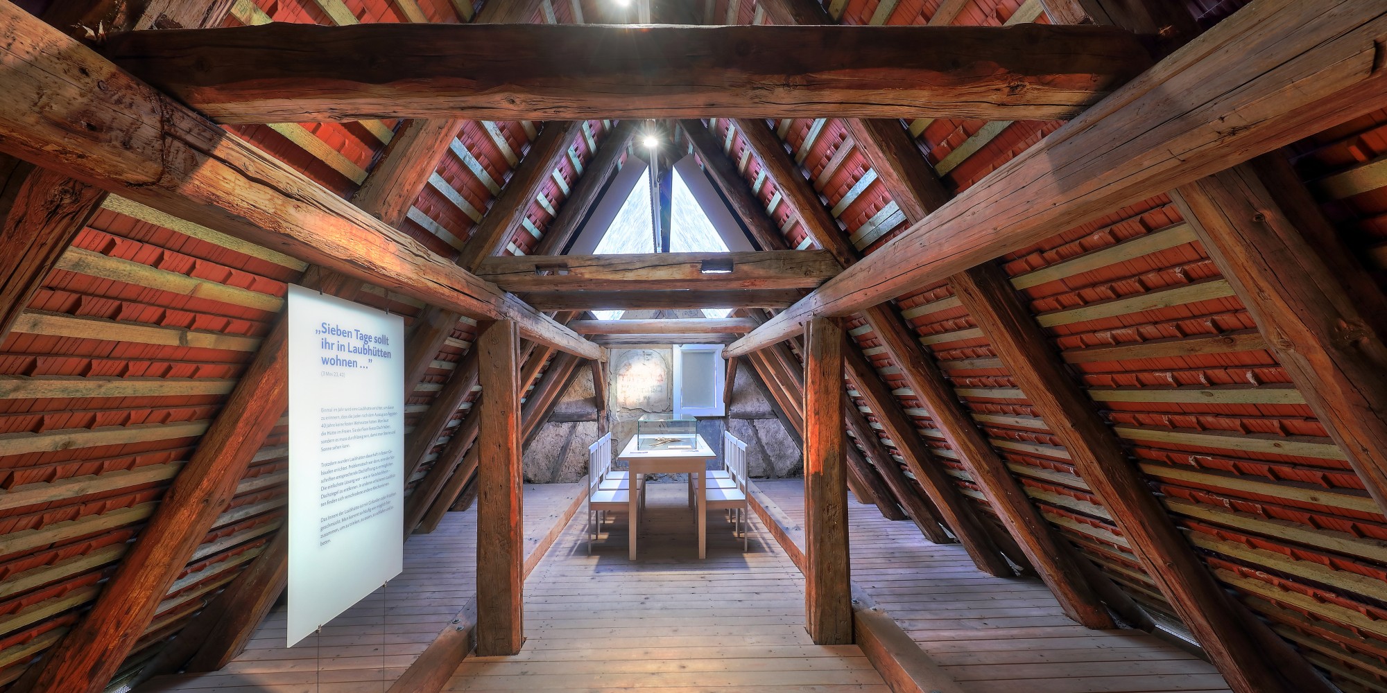 Dachboden eingerichtet als Laubh&uuml;tte mit Tisch, St&uuml;hlen und einem Wandfresko