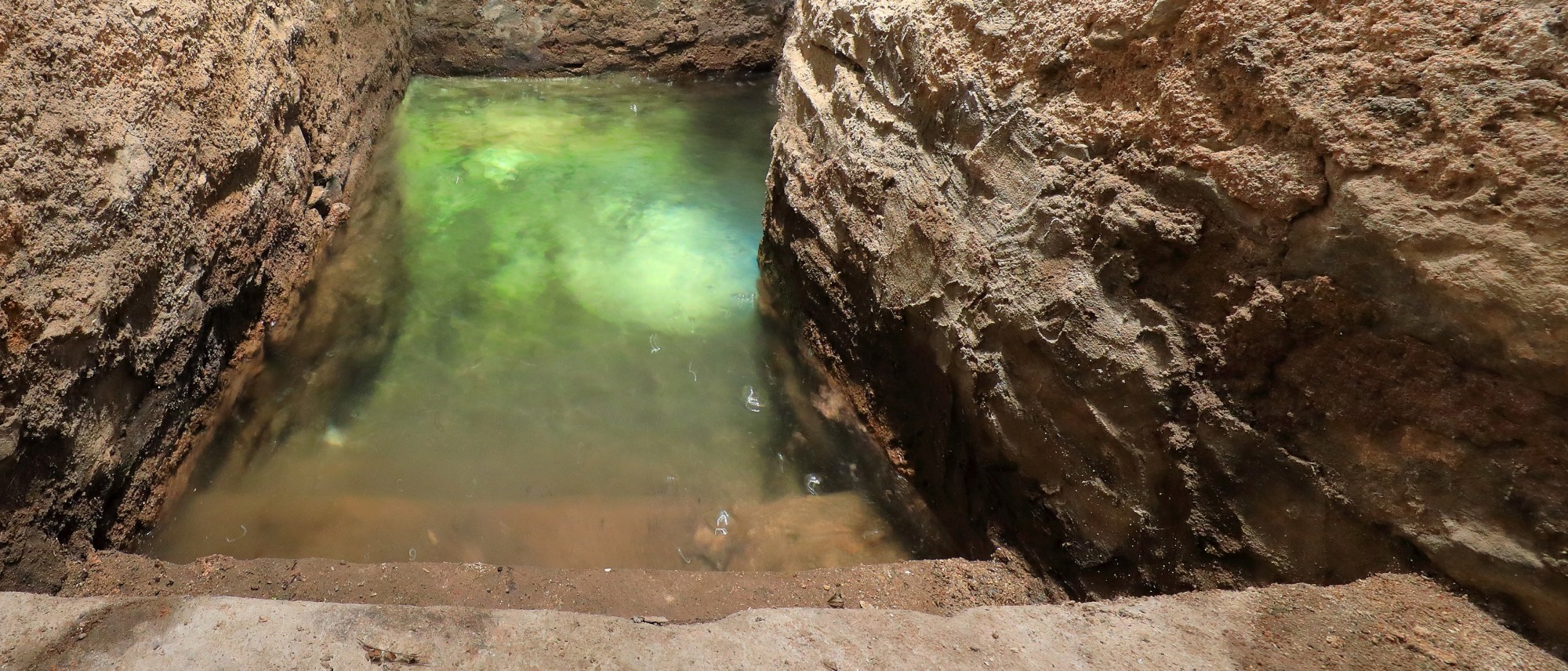 Stufen f&uuml;hren in ein Wasserbecken mit Grundwasser